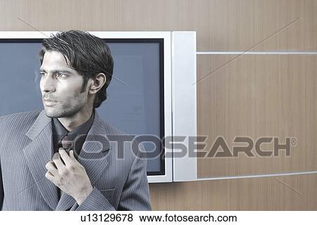 Close-up of a businessman adjusting his tie View Large Photo Image Stock Photo - Close-up of a businessman adjusting his tie. Fotosearch