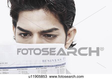 Stock Image - Close-up of a businessman reading a newspaper. Fotosearch