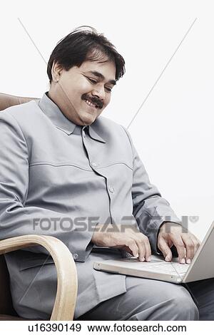 Close-up of a businessman working on a laptop View Large Photo Image Stock Photo - Close-up of a businessman working on a laptop. Fotosearch