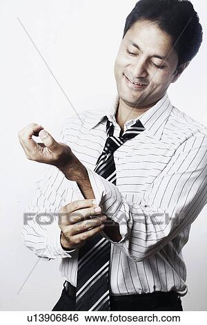 Close-up of a young man buttoning his cuff View Large Photo Image Stock Photograph - Close-up of a young man buttoning his cuff. Fotosearch