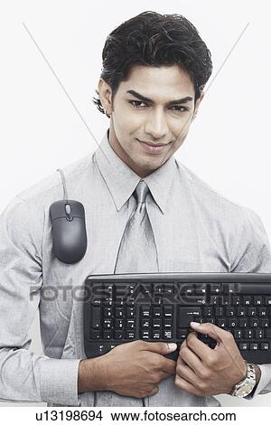 Portrait of a businessman holding a computer keyboard View Large Photo Image Picture - Portrait of a businessman holding a computer keyboard. Fotosearch