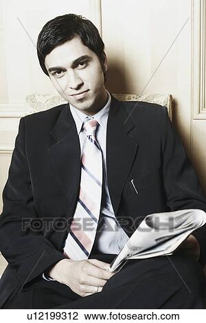 Stock Image - Portrait of a businessman holding a newspaper. Fotosearch