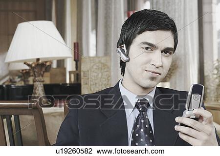 Portrait of a businessman holding a mobile phone View Large Photo Image Stock Image - Portrait of a businessman holding a mobile phone. Fotosearch
