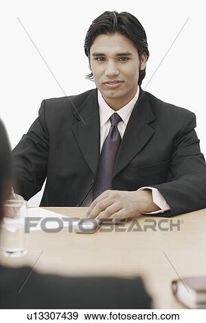Portrait of a businessman sitting in a conference room View Large Photo Image Stock Photo - Portrait of a businessman sitting in a conference room. Fotosearch