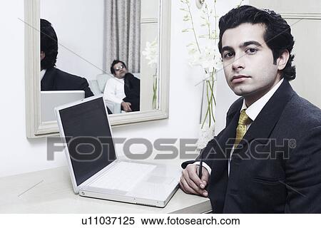 Stock Photography - Portrait of a businessman sitting in front of a mirror. Fotosearch