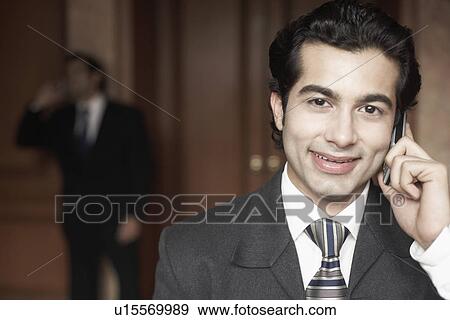Stock Photo - Portrait of a businessman talking on a mobile phone. Fotosearch