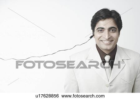 Stock Photograph - Portrait of a businessman using a hands free device. Fotosearch