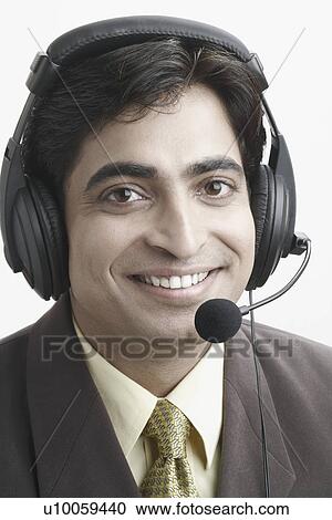 Stock Image - Portrait of a businessman wearing a headset. Fotosearch