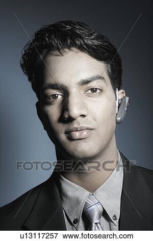 Stock Photo - Portrait of a businessman wearing a hands free device. Fotosearch