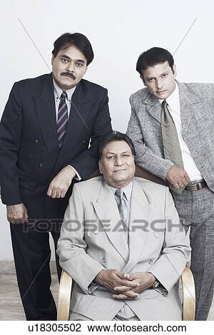 Stock Image - Portrait of a father and his two sons posing. Fotosearch