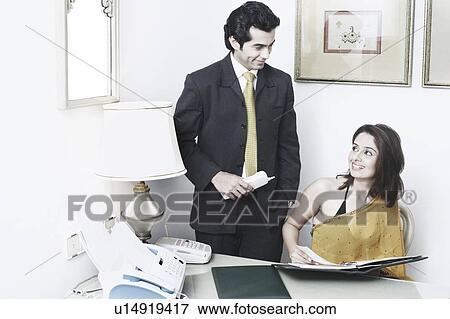 Stock Photo - Businessman and a businesswoman in an office. Fotosearch