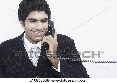 Businessman talking on the telephone smiling View Large Photo Image Stock Photo - Businessman talking on the telephone smiling. Fotosearch