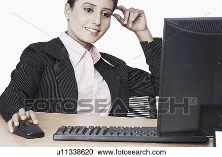 Stock Image - Close-up of a businesswoman working on a computer. Fotosearch