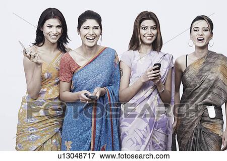 Close-up of four young women holding mobile phones View Large Photo Image Stock Photo - Close-up of four young women holding mobile phones. Fotosearch
