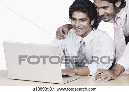 Close-up of two businessmen using a laptop View Large Photo Image Stock Photo - Close-up of two businessmen using a laptop. Fotosearch