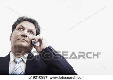 Low angle view of a businessman talking on a mobile phone View Large Photo Image Stock Photo - Low angle view of a businessman talking on a mobile phone. Fotosearch
