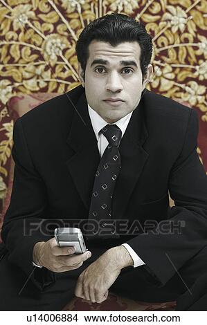 Picture - Portrait of a businessman holding a mobile phone. Fotosearch