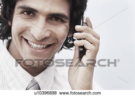 Portrait of a businessman holding a mobile phone View Large Photo Image Stock Photo - Portrait of a businessman holding a mobile phone. Fotosearch