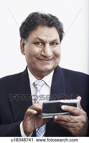 Portrait of a businessman operating a mobile phone View Large Photo Image Stock Image - Portrait of a businessman operating a mobile phone. Fotosearch