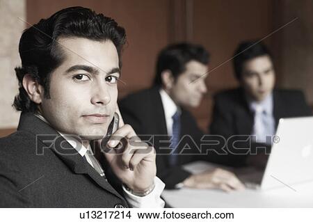 Picture - Portrait of a businessman talking on a mobile phone. Fotosearch