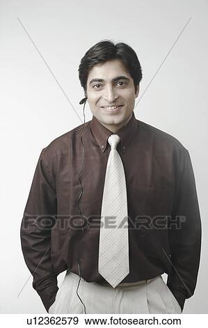 Stock Photo - Portrait of a businessman using a hands free device. Fotosearch