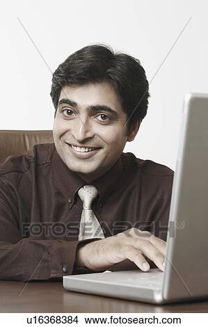 Picture - Portrait of a businessman using a laptop. Fotosearch