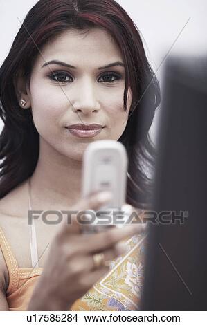 Picture - Portrait of a businesswoman holding a mobile phone. Fotosearch