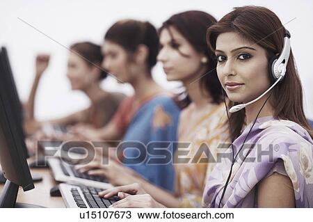 Stock Image - Portrait of a businesswoman sitting in front of a computer. Fotosearch