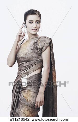 Stock Image - Portrait of a young woman wearing a hands free device. Fotosearch