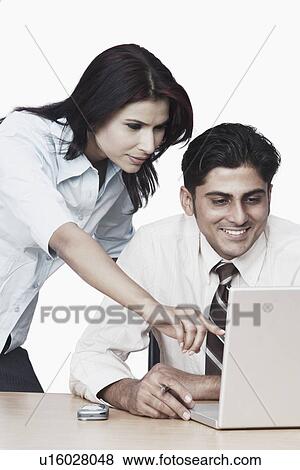 Businessman and a businesswoman using a laptop View Large Photo Image Stock Photo - Businessman and a businesswoman using a laptop. Fotosearch