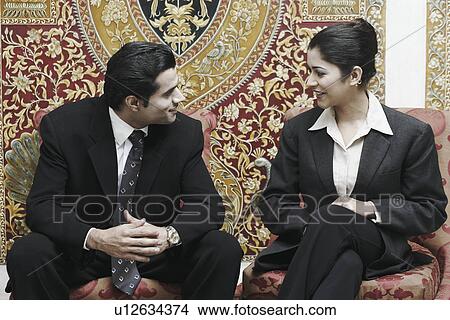 Picture - Close-up of a businessman and a businesswoman talking. Fotosearch