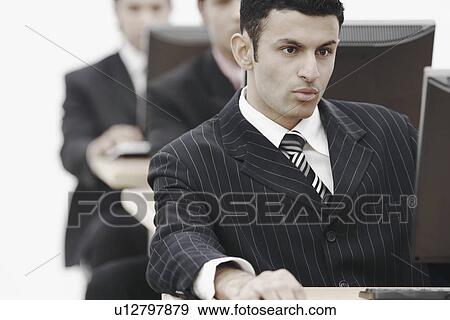 Stock Photo - Close-up of a businessman working on a computer. Fotosearch