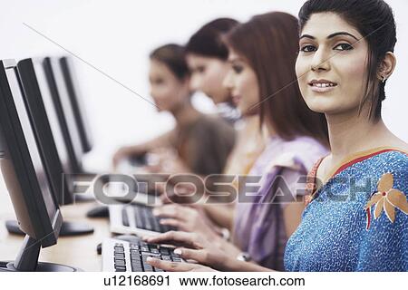 Close-up of four businesswomen sitting in front of computers View Large Photo Image Stock Image - Close-up of four businesswomen sitting in front of computers. Fotosearch