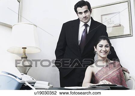 Stock Image - Portrait of a businessman and a businesswoman in an office. Fotosearch