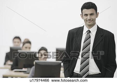 Stock Photograph - Portrait of a businessman standing in an office. Fotosearch