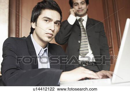 Stock Image - Portrait of a businessman using a laptop. Fotosearch