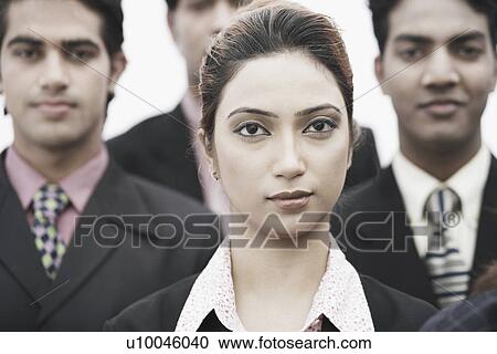 Stock Image - Portrait of a businesswoman standing with three businessmen. Fotosearch