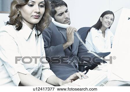 Stock Photo - Two businesswomen and a businessman in an office. Fotosearch