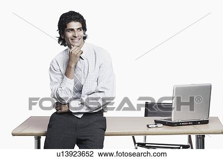 Stock Image - Close-up of a businessman leaning against a table. Fotosearch