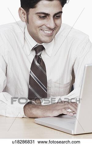 Stock Image - Close-up of a businessman working on a laptop. Fotosearch