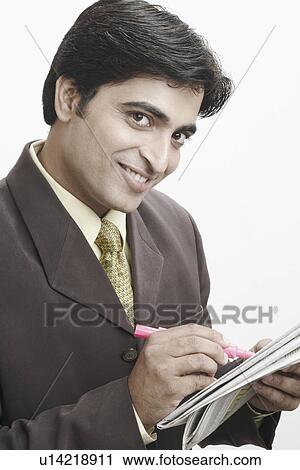 Stock Image - Portrait of a businessman holding a newspaper. Fotosearch
