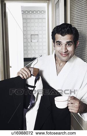 Portrait of a businessman holding a hanger View Large Photo Image Stock Image - Portrait of a businessman holding a hanger. Fotosearch