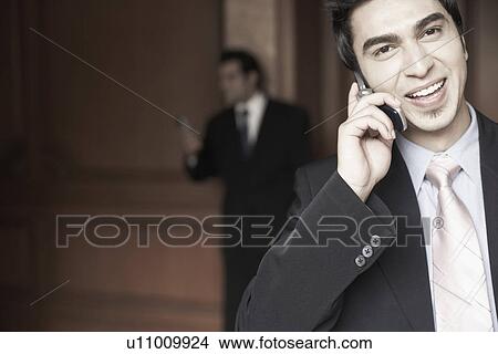 Picture - Portrait of a businessman talking on a mobile phone. Fotosearch