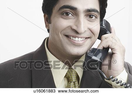 Stock Image - Portrait of a businessman talking on the telephone. Fotosearch
