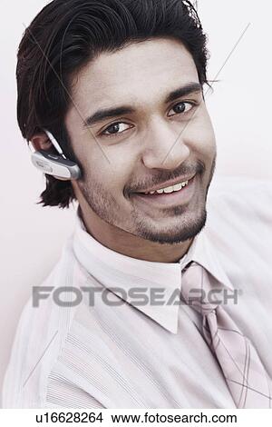 Picture - Portrait of a businessman wearing a hands free device. Fotosearch