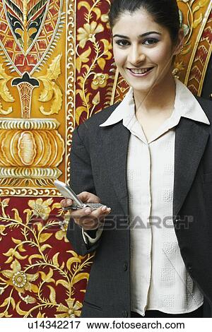 Portrait of a businesswoman holding a mobile phone View Large Photo Image Stock Photo - Portrait of a businesswoman holding a mobile phone. Fotosearch