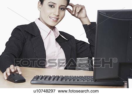 Stock Photo - Portrait of a businesswoman sitting in front of a computer. Fotosearch