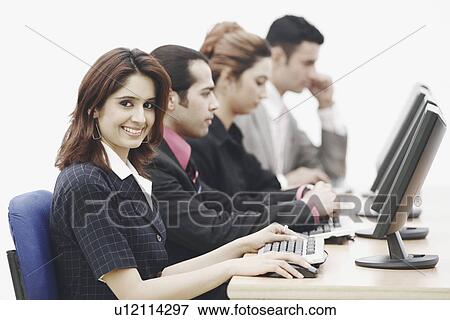 Portrait of a businesswoman sitting in front of a computer View Large Photo Image Stock Photo - Portrait of a businesswoman sitting in front of a computer. Fotosearch