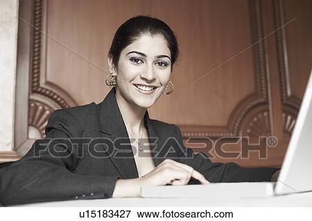 Stock Photo - Portrait of a businesswoman using a laptop. Fotosearch