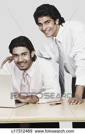 Portrait of two businessmen in front of a laptop View Large Photo Image Stock Photo - Portrait of two businessmen in front of a laptop. Fotosearch